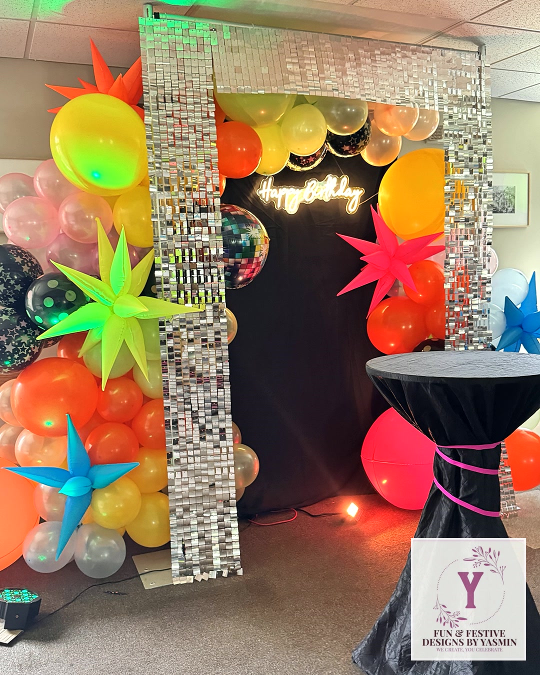 Colorful balloons surrounding a sparkling birthday photo backdrop