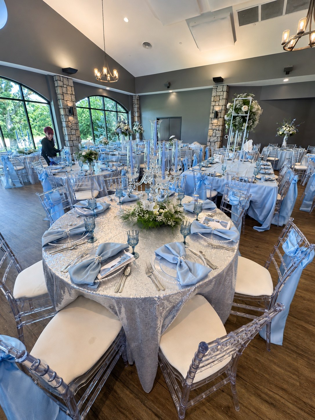 Coordinated blue linens and floral arrangements in a bright reception room
