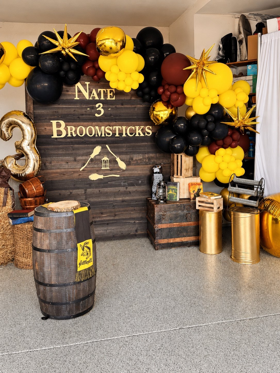 Nate’s third birthday backdrop with black and yellow balloons, barrels and lanterns
