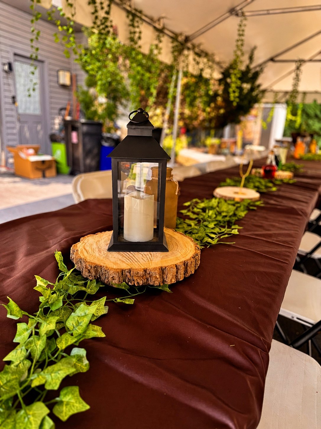 Rustic themed party tables with lantern centerpieces and greenery