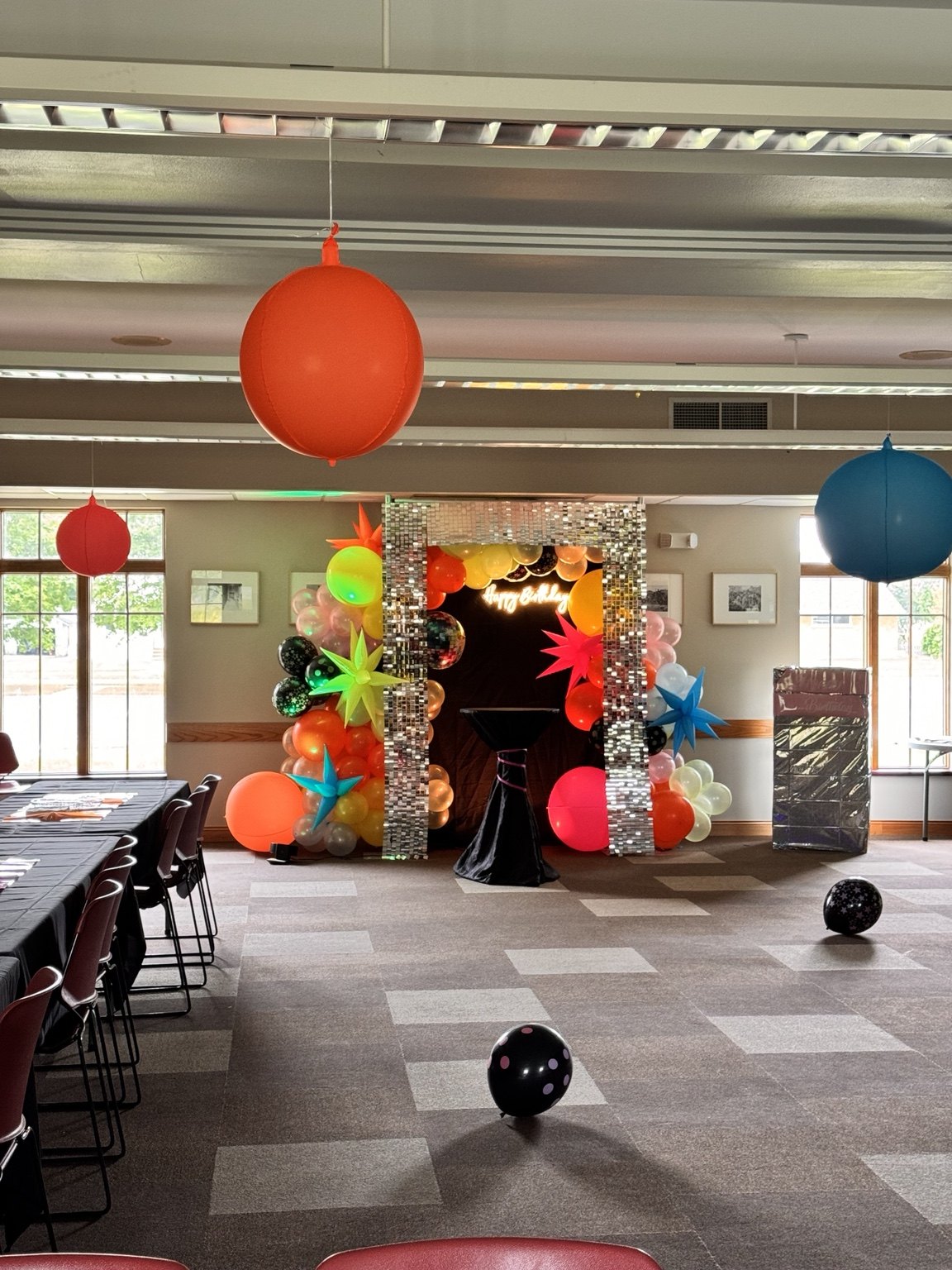 Bright balloon decorations and a party backdrop in an indoor venue