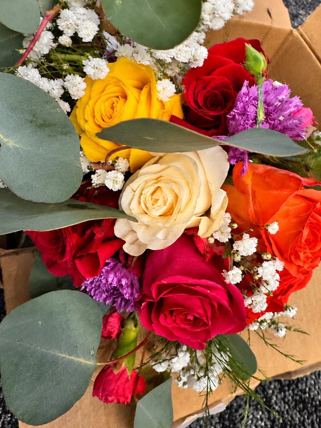 Colorful rose arrangement with yellow, red, cream and purple flowers