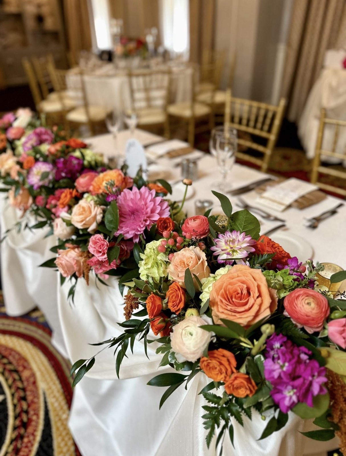 Colorful floral arrangement with roses and greenery on an elegant reception table
