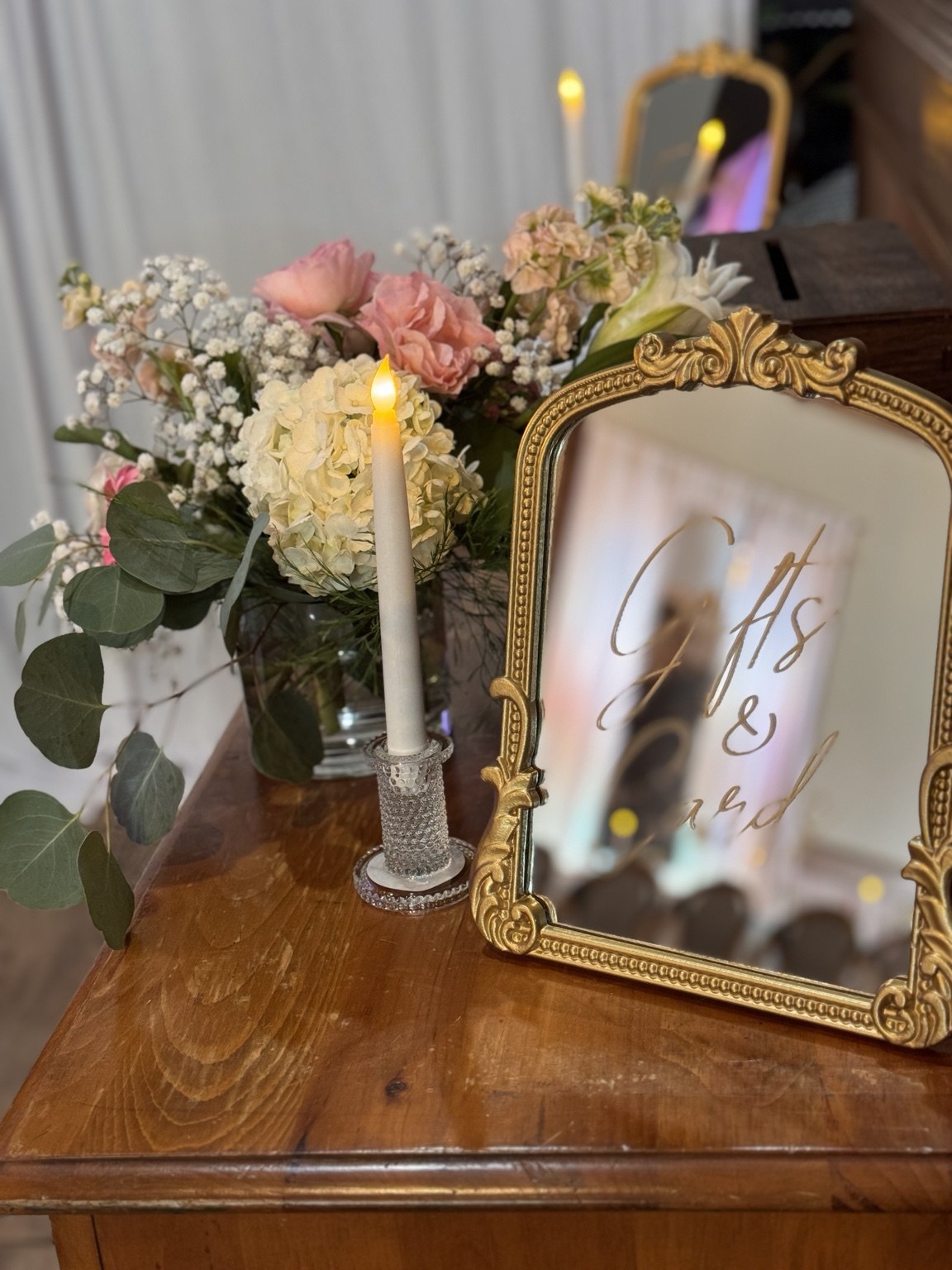 Gold framed wedding sign with candles and pink floral arrangements