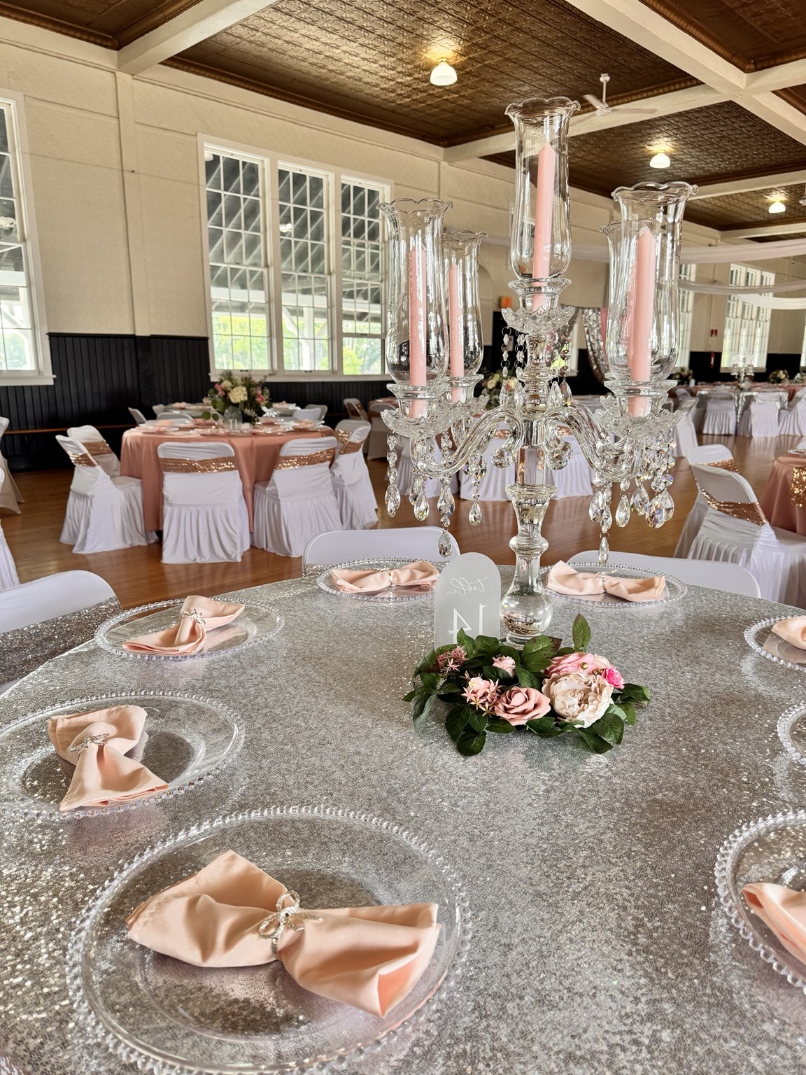 Silver sequin tablecloth with blush bow napkins and a crystal candelabra
