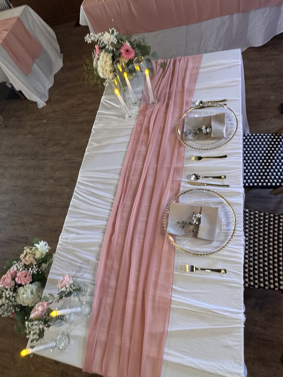 White sweetheart table with blush runner, gold chargers and pink and white flowers