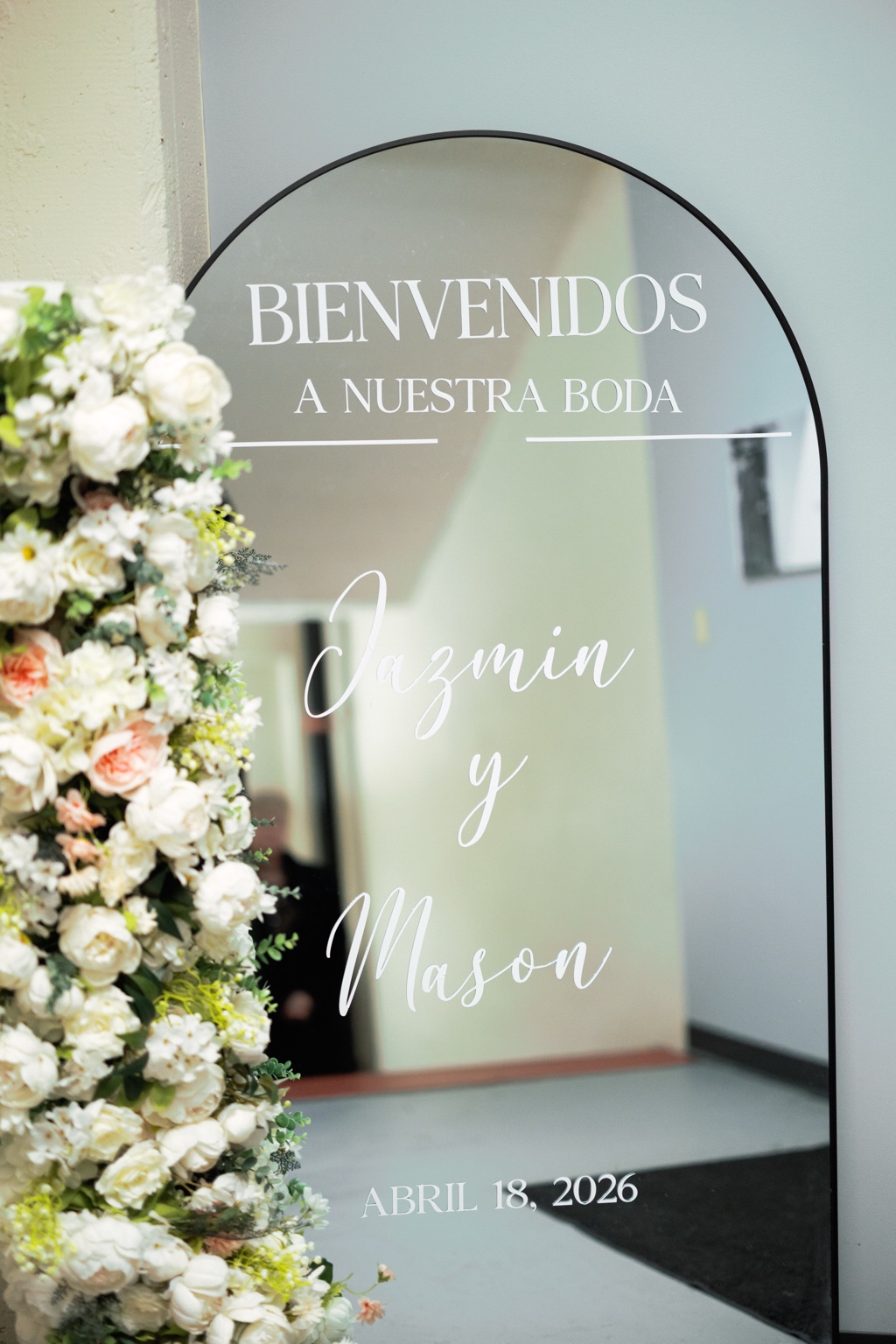 Wedding mirror welcome sign framed by white flowers